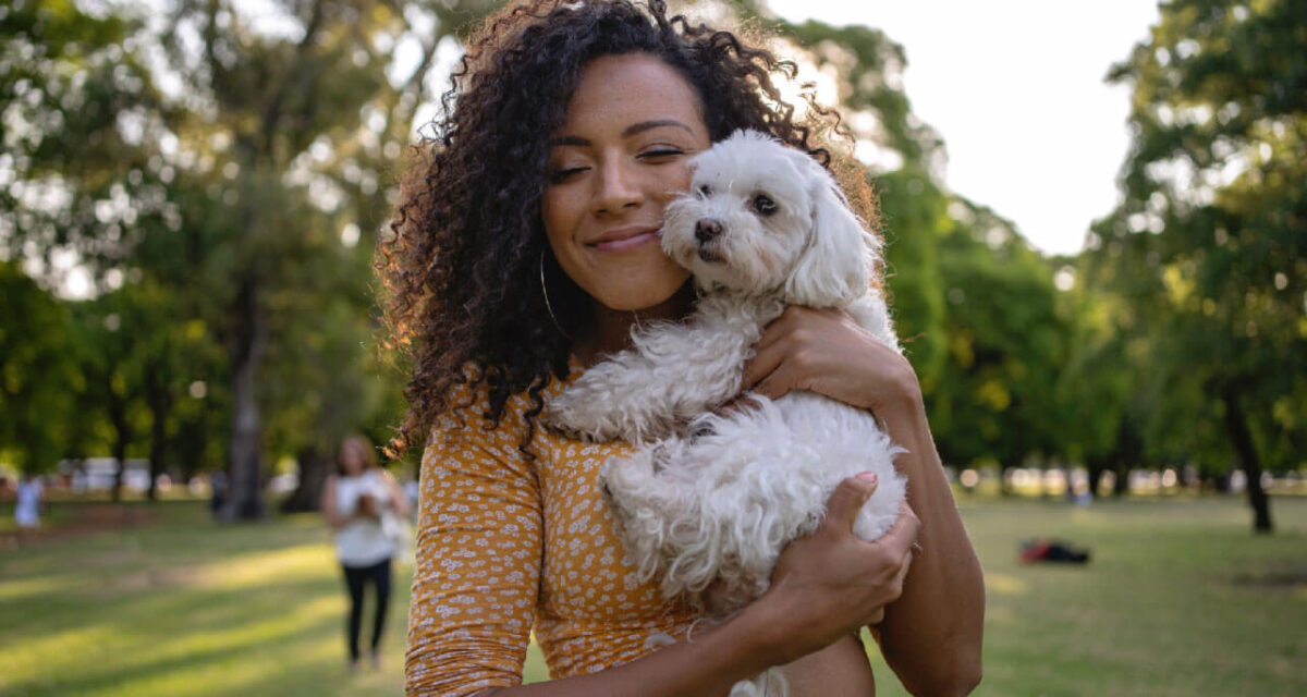 young-lady-cuddling-a-small-white-dog